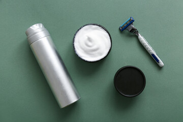Set of shaving accessories on green background