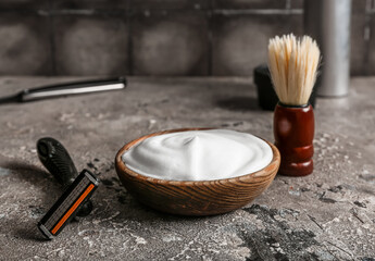 Set of shaving accessories on grunge grey table near tile wall