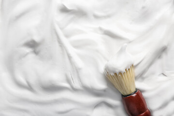 Texture of shaving foam with brush as background, closeup
