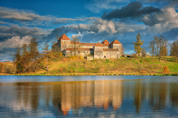 Naklejka na ściany i meble lake view to medieval castle under rainy clouds in autumn day