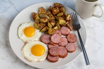 fried eggs  with sliced kielbasa  and home fries