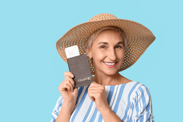 Mature woman with passport on blue background, closeup. Travel concept