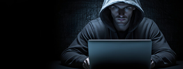hacker man with his laptop about to hack and commit a cyber crime - obrazy, fototapety, plakaty