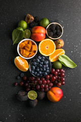 Assortment of fresh exotic fruits and berries on concrete table, flat lay