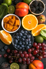Assortment of fresh exotic fruits and berries on concrete table, flat lay
