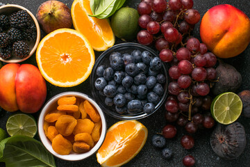 Assortment of fresh exotic fruits and berries on concrete table, flat lay