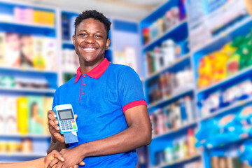 young happy african shopkeeper receiving payment with pos machine