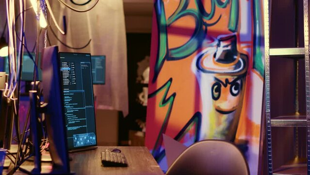 Graffiti painted empty hideaway base with lines of code running on computer screen with malware that get past security systems. PCs in deserted bunker showing scripts that can hack devices