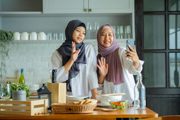 Cute Girl And Her Muslim Mom In Hijab Preparing Pastry For Cookies In Kitchen, Baking Together At Home. Islamic Lady With Daughter Enjoying Doing Homemade Pastry