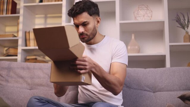Unhappy handsome man received parcel dissatisfied with shopping in online internet store hold smartphone for conflict bad feedback problem with service or delivery while call in hot line at home 