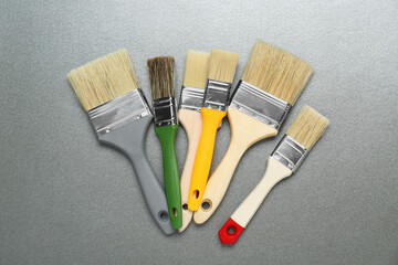 Many different paint brushes on grey background, flat lay