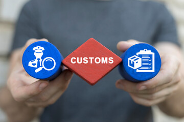 Man holding multi-colored blocks sees word: CUSTOMS. Concept of customs. Customs declaration...