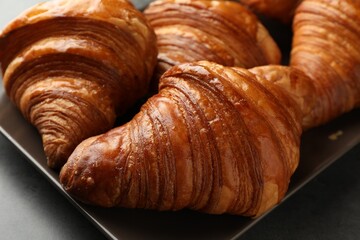 Delicious fresh croissants on grey table, closeup