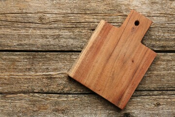 Fototapeta premium One new cutting board on old wooden table, top view. Space for text