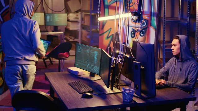 Hacker group coordinating DDoS attack on website, sending large amounts of traffic from multiple sources to overwhelm it. Rogue programmers working together to flood target server, slowing it down