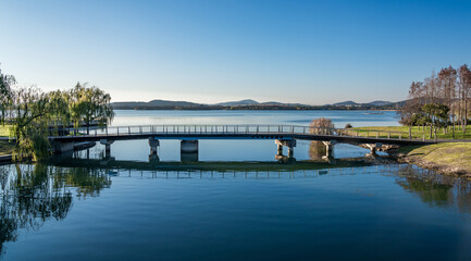 A pedestrian bridge in a city park by the lake