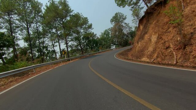 Long right hand corner, POV shot from action camera on long winding road in the mountains north of Pai, part of the Mae Hong Son loop.