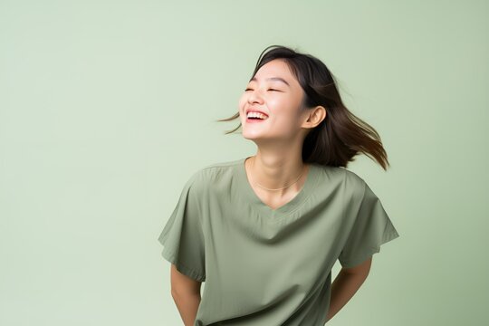 Portrait of a joyful fictional Japanese woman smiling. Graceful and elegant lady. Natural beauty. Happiness. Isolated on a plain colored pastel background. Generative AI.