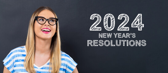 2024 New Years Resolutions with happy young woman in front of a blackboard
