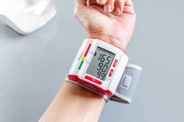 Hypertension. Tensiomètre de poignet. Automesure indiquant une tension artérielle de 16.9 