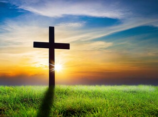 Silhouette christian cross on grass in sunrise background