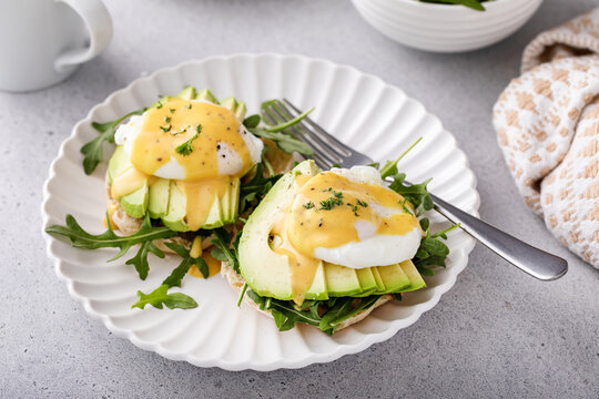 English muffins with arugula, avocado and poached eggs, healthy eggs benedict