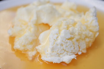 butter cream and honey in a bowl on table .