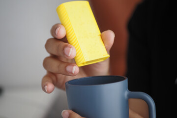 young women putting artificial sweetener in tea,