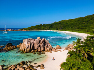 Obraz premium Anse Cocos beach, La Digue Island, Seychelles, Drone aerial view of La Digue Seychelles bird eye view of a tropical Island, couple men and woman walking at the beach during sunset at a luxury vacation