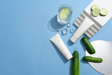 Two white tubes decorated with a staircase, ices and a mirror. A glass of cucumber detox water is...