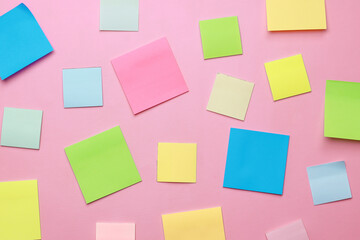 Blank multicolor sticky notes on pink background.