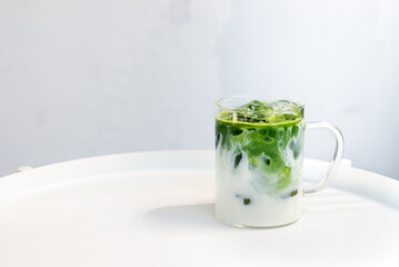 ice matcha green tea latte on white table.