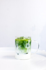 ice matcha green tea latte on white table.