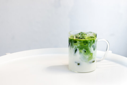 ice matcha green tea latte on white table.