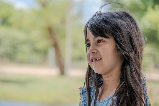 Beautiful little girl pictured in a park while talking.
