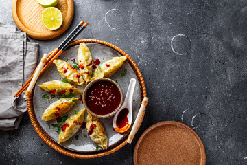 Asian dumplings with hot sauce on the grey background top view copy space for text