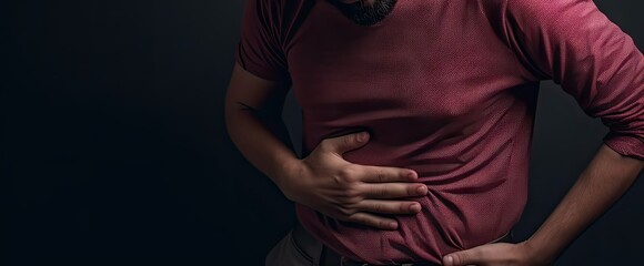 Young caucasian man holding stomach in pain. Digestive distress. Unwell adult suffering from stomachache and discomfort - obrazy, fototapety, plakaty
