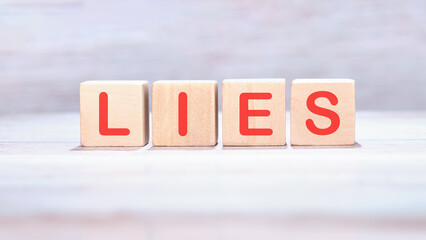 Lies word made of wooden cubes on a light background