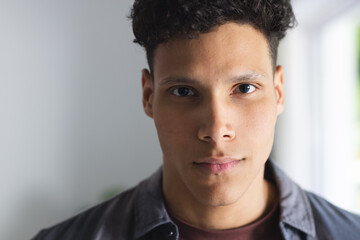 Portrait of serious biracial man in living room at home, copy space