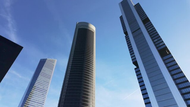 Four skyscraper towers in Madrid on a sunny day with blue skies.