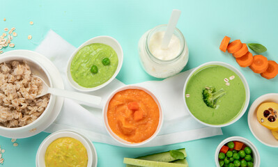 Bowls with different healthy baby food.