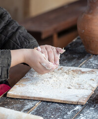 A woman kneads the dough with her hands