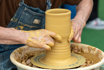 Clay craftsman sculpts crockery . Close-up.