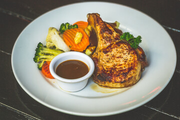 Succulent 300gm bone in pork chop served with mashed potatoes, buttered vegetables and finished with homemade LP sauce