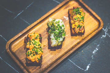 an appetizer of pan fried potato rectangles with a bed Avocado mousse and .Beef Tartare, Spicy...