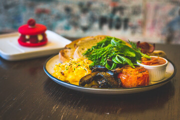 Big Breakfast.Eggs (scrambled/ sunny side up/ omelette), artisanal sourdough, sautéed tomato, sautéed mushroom, baked beans, pork sausage, bacon and salad.