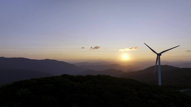 Wind power generator on the mountain against the background of the sunrise. 풍력 발전기, 풍력 터빈, 일출.	