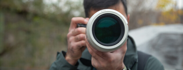 Fototapeta premium Man taking picture by professional camera in outdoor.