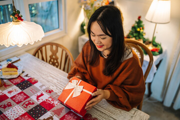 Obraz na płótnie Canvas Happy excited asian woman hands holding Christmas gift box. cheerful girl packing Xmas present or open box xmas new year birthday gift.