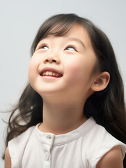 Asian little girl smiling and looking up portrait